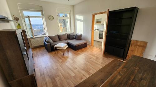 a living room with a couch and a table at Ruhiger Flussblick vom Balkon in Niederdorla