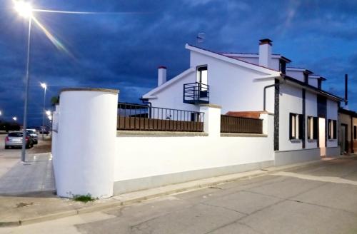 een wit huis aan een straat met een straatlantaarn bij El Romazal in Nava de la Asunción