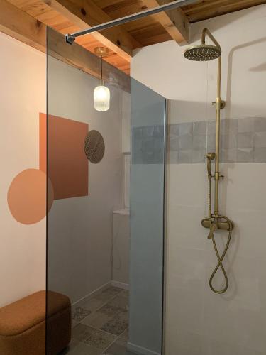 a shower with a glass door in a bathroom at la bastilac chambre terracotta in Garganvillar