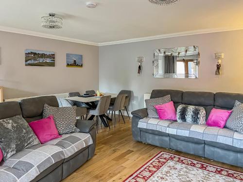 a living room with two couches and a table at Rivendell Lodge - Cottage in East Winch