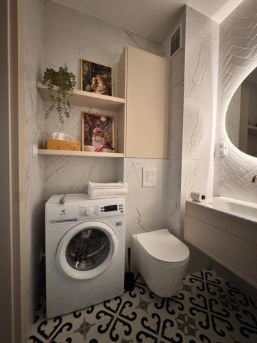 a bathroom with a washing machine and a toilet at Terra Rosa in Radom