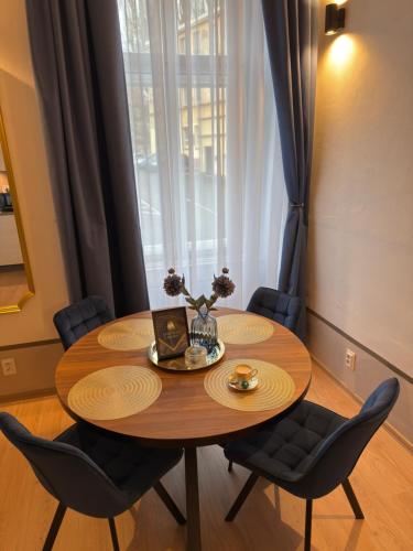 a dining room table with chairs and a window at Apartmán U Hradu in Strakonice
