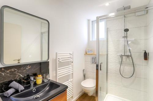 a bathroom with a sink and a shower and a toilet at L'Escapade Médiévale Appartement neuf in Josselin