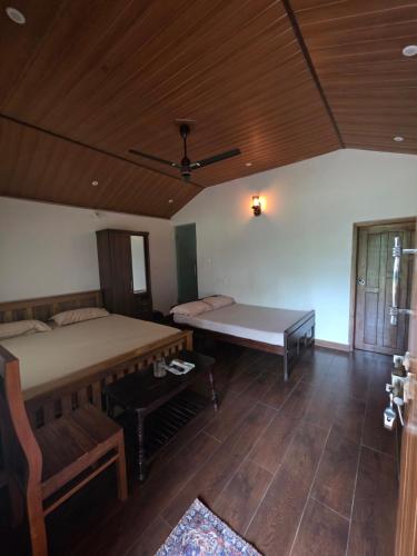 a bedroom with a bed and a table in it at Naad Alaya Estate Stay in Siddapur