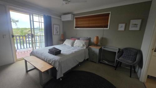 a bedroom with a bed and a chair and a window at Terrace River House in Caddys Island