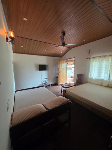 a bedroom with a large bed and a wooden ceiling at Naad Alaya Estate Stay in Siddapur