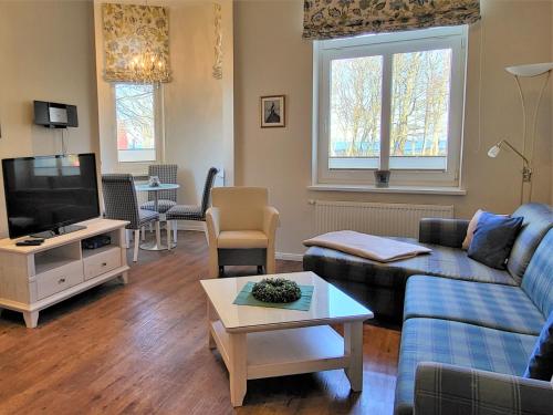 a living room with a couch and a tv at Hotel Hubertusburg in Kühlungsborn