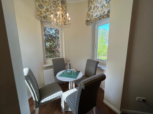 a dining room with a table and chairs and a chandelier at Hotel Hubertusburg in Kühlungsborn