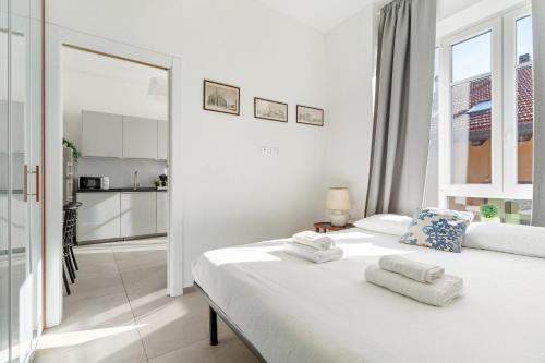 a white bedroom with a bed with towels on it at Baroni C - FREE private parking-wi- fi and A-C in Gerenzano