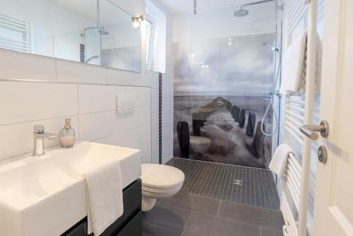 a white bathroom with a sink and a toilet at Haus Uthlande Uthlande Whg 49 Inselauszeit in Wyk auf Föhr