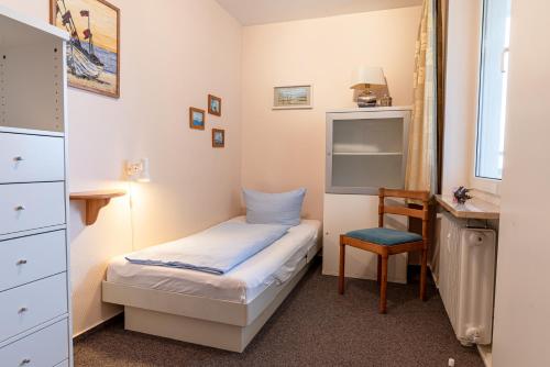 Un dormitorio con una cama, un escritorio y una silla. en Haus Uthlande Uthlande Whg 23 Lütte Bris, en Wyk auf Föhr