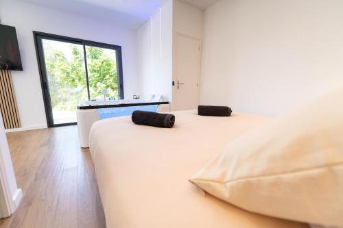 Romantic suite with jacuzzi في لا ترينيتيه: سريرين في غرفة ذات نافذة كبيرة