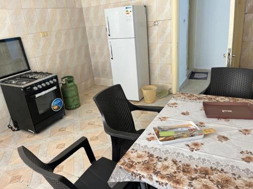a kitchen with a table with chairs and a refrigerator at 2 Bedroom apartment in Jerash Centre in Jerash
