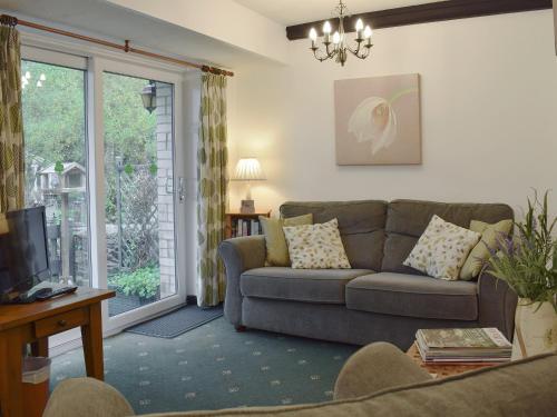 a living room with a couch and a window at Ivy Cottage in Henllan
