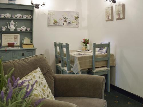 a living room with a table and a chair at Ivy Cottage in Henllan