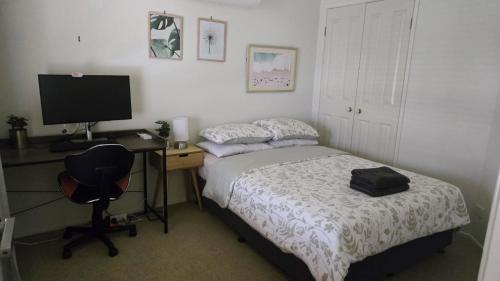 a bedroom with a bed and a desk with a computer at Terrace River House in Caddys Island