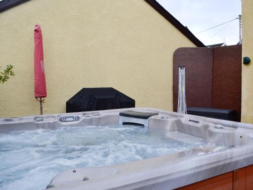 a jacuzzi tub with water in it next to a building at Ty Glyndwr in Ystalyfera