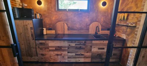 a kitchen with a counter with a sink and a refrigerator at Étang des Tamaris in Namur