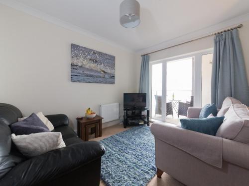 a living room with a couch and a television at Lower Chine Apartment in Shanklin