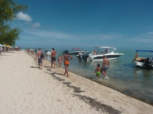 a group of people walking on a beach with a boat at Cool Studio in Flic-en-Flac