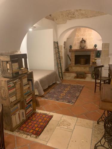 een woonkamer met een bed en een open haard bij Trulli Santa Maria Odegitria Relais in Ostuni
