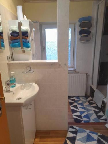 a white bathroom with a sink and a window at Ferienwohnung Monika Staßfurt OT Üllnitz an der A14 in Glöthe