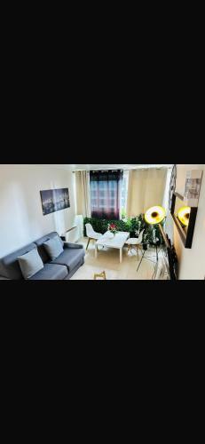 een woonkamer met een bank en een tafel bij Suite vue sur la Tour Eiffel in Courbevoie