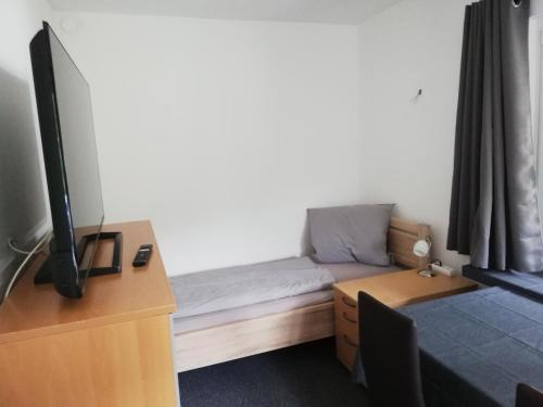 a room with a bed and a desk with a tv at Monteurzimmer - zwischen Hamburg & Lübeck in Todendorf