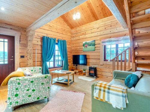 a living room with a couch and a tv in a cabin at Ty Afal - Uk42099 in Carno