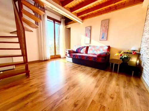 a living room with a red couch and wooden floors at Hotel New Genziana in Altavilla Vicentina
