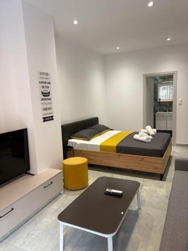 Un dormitorio con una cama, un televisor y una mesa. en Elysion, en Drama