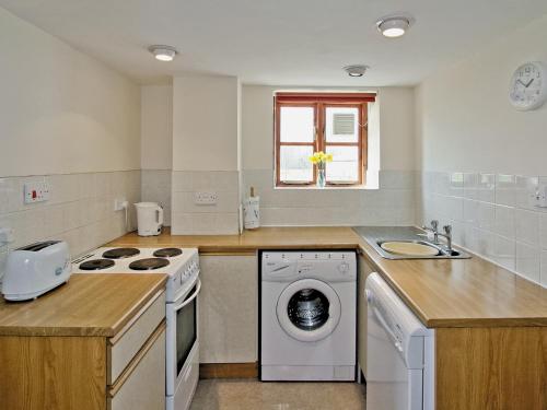 a kitchen with a washing machine and a sink at Barrowmead Cottage - E2377 in Banwell