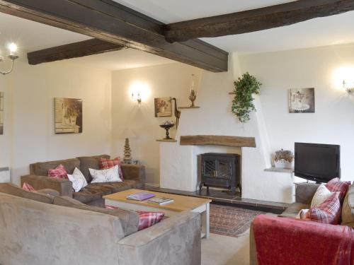 een woonkamer met twee banken en een open haard bij Dray Cottage in East Allington