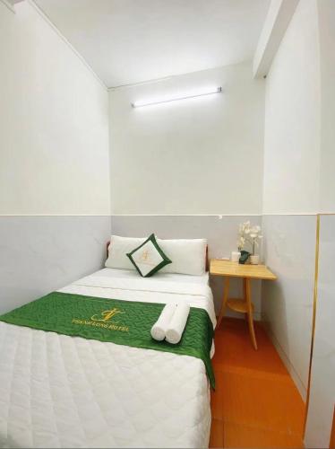 a small bedroom with a bed and a table at Thanh Long Hotel in Ho Chi Minh City
