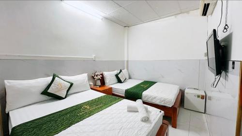 胡志明市Thanh Long Hotel的一间设有两张床和电视的房间