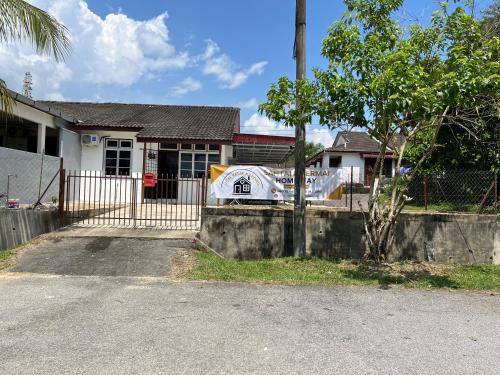 a house with a car parked in front of it at Santai DPermai Homestay in Selama