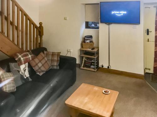 MelmerbyにあるElseghyll Barnのソファとテレビのあるリビングルーム