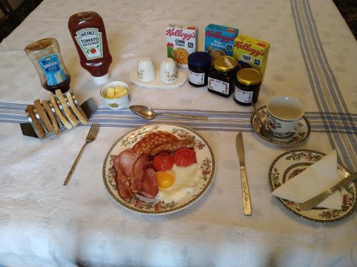 einen Tisch mit einem Frühstück mit Eiern Speck und Toast in der Unterkunft Hillside Farm in Carlisle