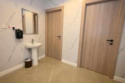 a bathroom with a sink and a wooden door at بيت سلسبيل in Al Madinah