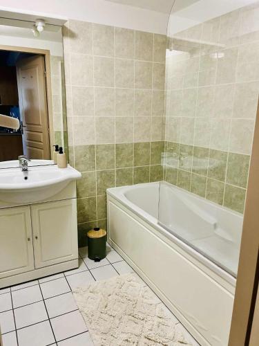 a bathroom with a white tub and a sink at Le Clos du Green in Levernois