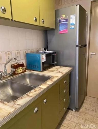 una cocina con fregadero y refrigerador en El lugar soñado, en Mar del Plata
