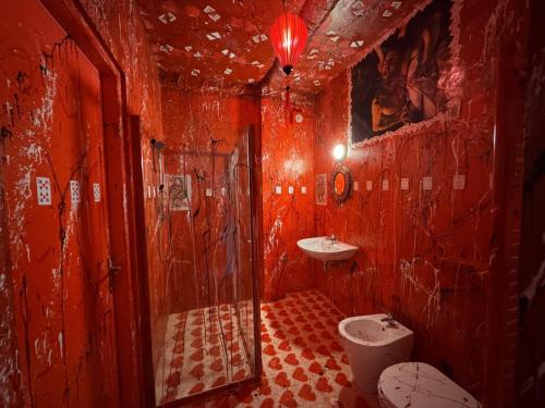 a red bathroom with a toilet and a sink at Paciu Maison in Ozzano dell Emilia