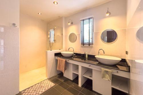 a bathroom with two sinks and two mirrors at Charming 3BR villa with Private pool in Bangrak Beach