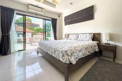 a bedroom with a bed and a large window at Charming 3BR villa with Private pool in Bangrak Beach