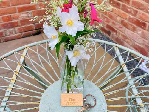 a vase filled with flowers sitting on a table at The Parlour in Earls Croome