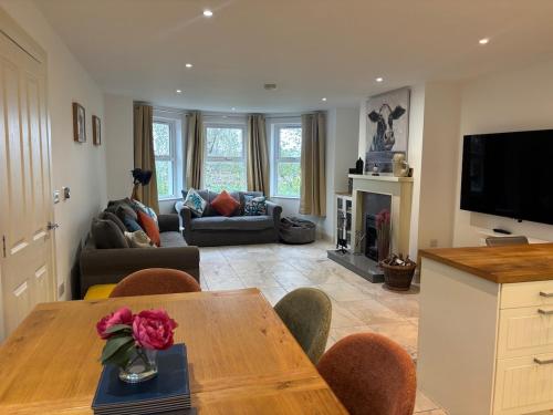 a living room with a table and a couch at Rosemarinus a Peaceful 4Bed 3Bath Townhouse Ballycastle in Ballycastle