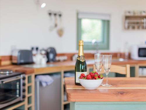 a bottle of champagne and a bowl of strawberries on a kitchen counter at Bay in Wootton Bridge