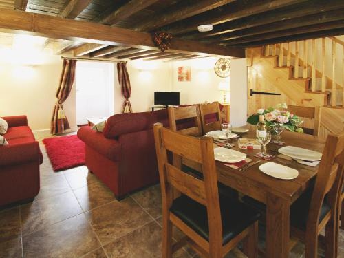 ein Esszimmer mit Tisch und Couch in der Unterkunft Granary Cottage - E5626 in Wainfleet All Saints