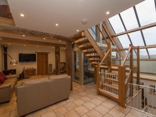 a living room with a staircase and a couch at Y Beudy in Efenechtyd