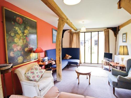 a living room with orange walls and blue furniture at The Granary - E3669 in Saxtead